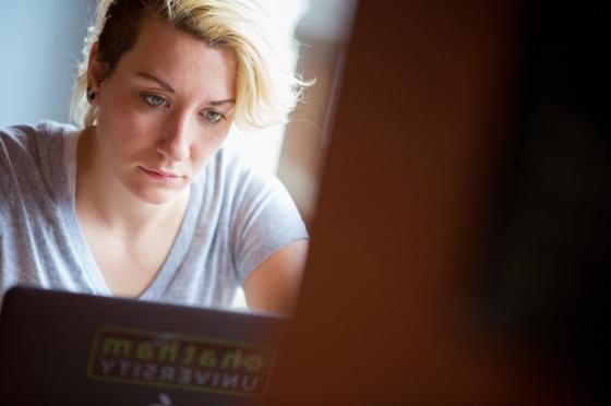 Photo of a female Chatham University student looking at a laptop