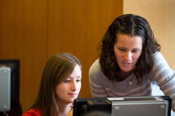 Two Chatham University female students working at a computer together