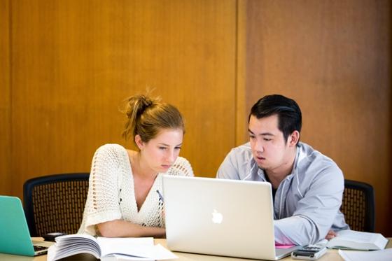 Photo of two Chatham University students looking at a laptop together.